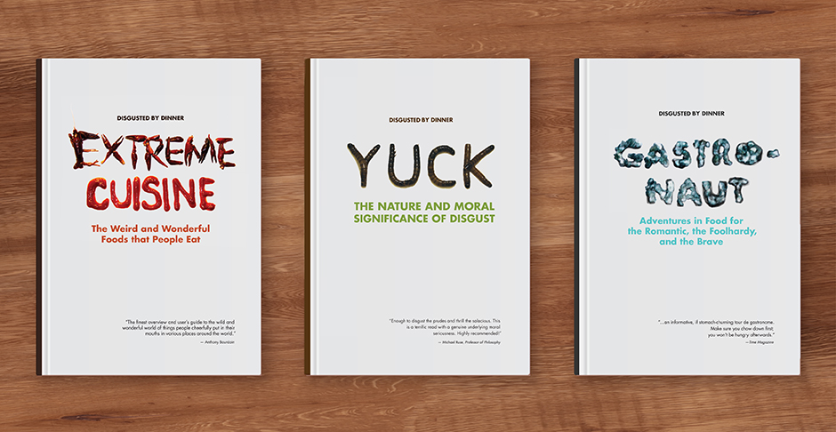 Three white books laying flat on a wood floor. The titles are 'Extreme Cuisine', 'Yuck' and 'Gastronaut'