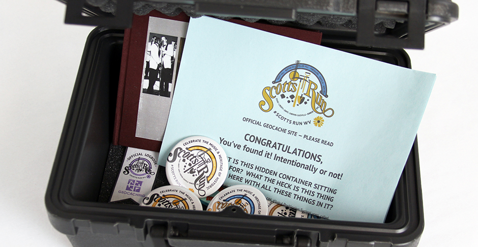 Inside Geocache for Scott's Run that includes a log book, instructions and a takeaway button