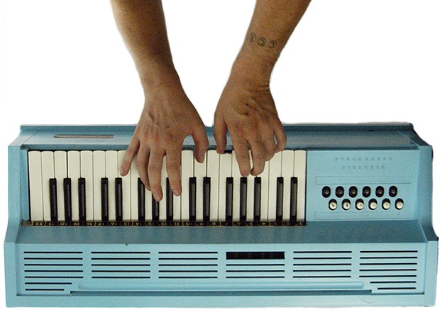 Hands playing turquoise keyboard